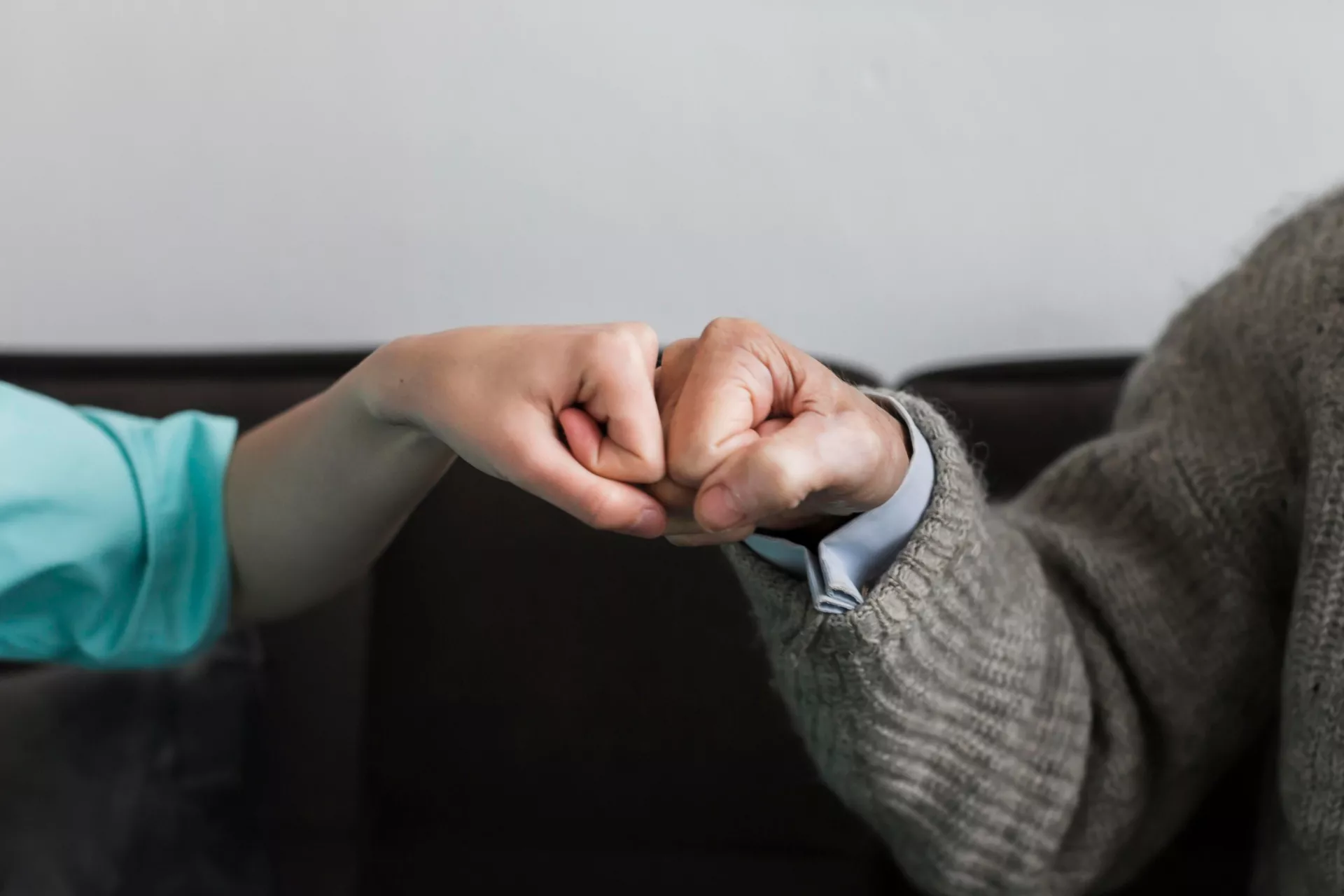 Nurse older man fist bumping